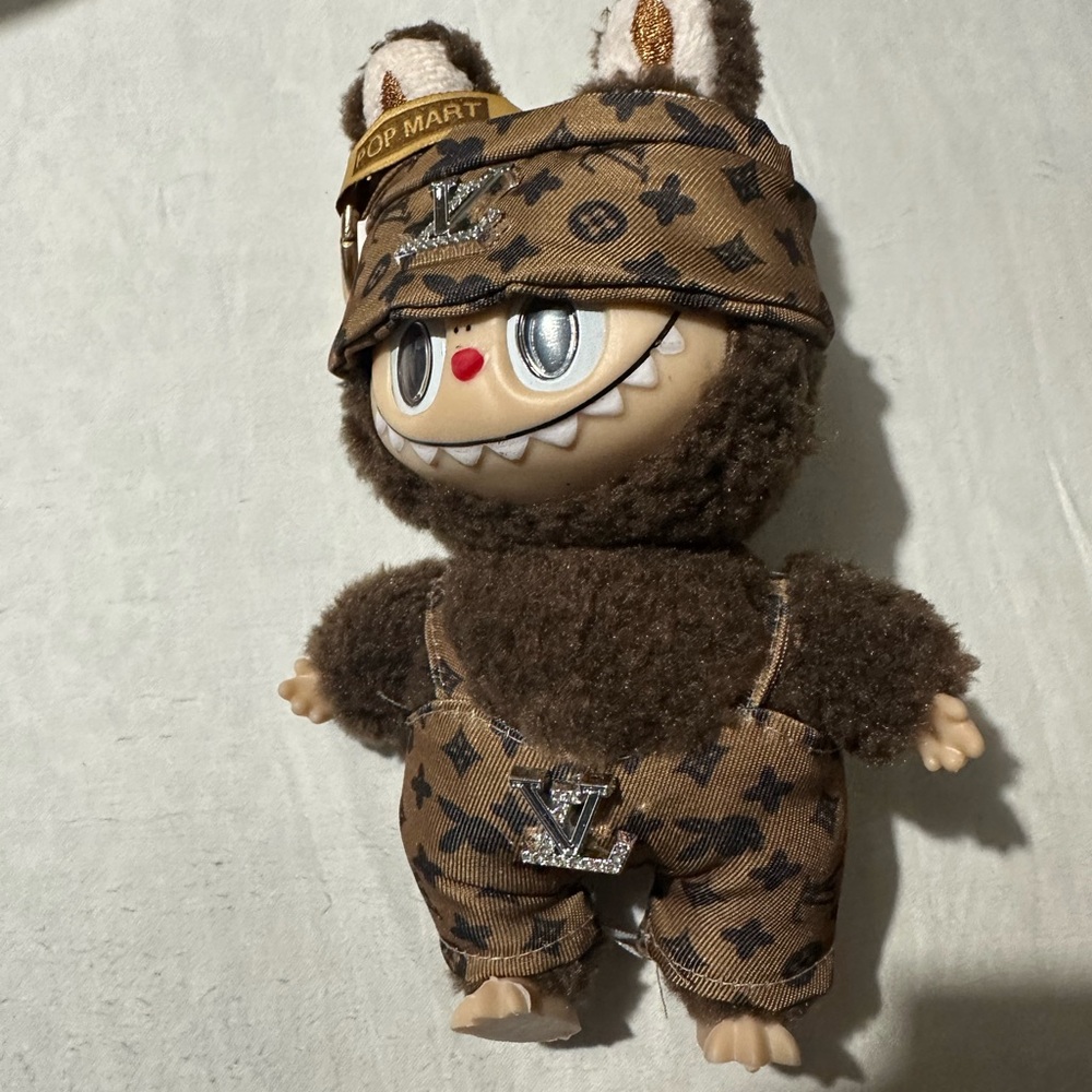 Brown plushy doll with clothes. Not a real Labubu. But a good look like.